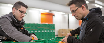 Mitarbeitende mit Orangenkisten Mitarbeitende mit Orangenkisten